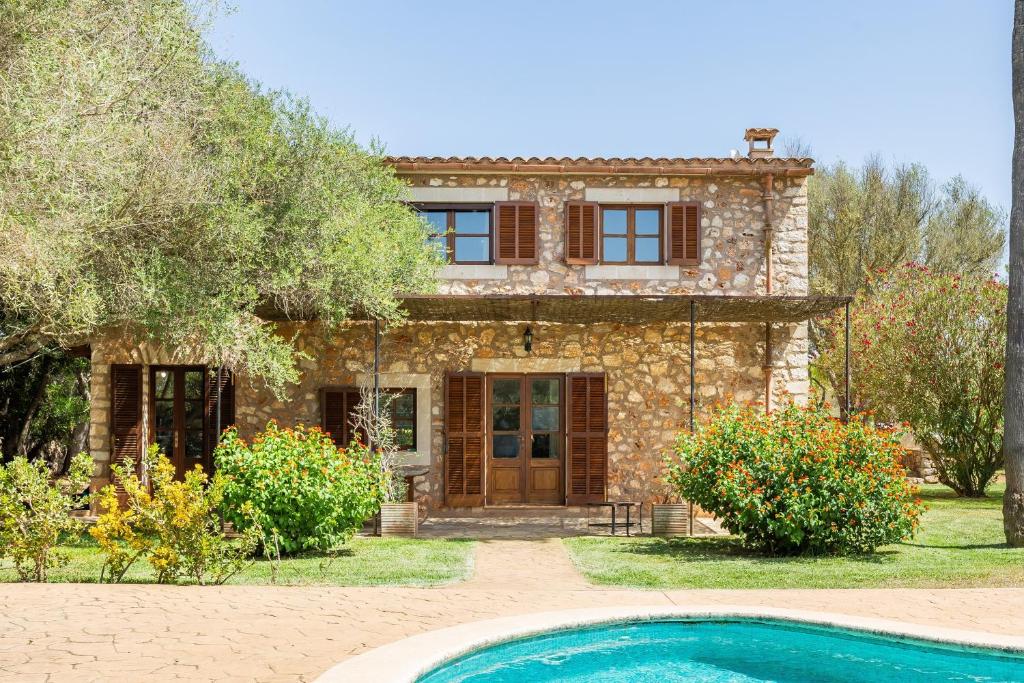 a stone house with a swimming pool in front of it at Mirabo ramonet in Caʼs Concos