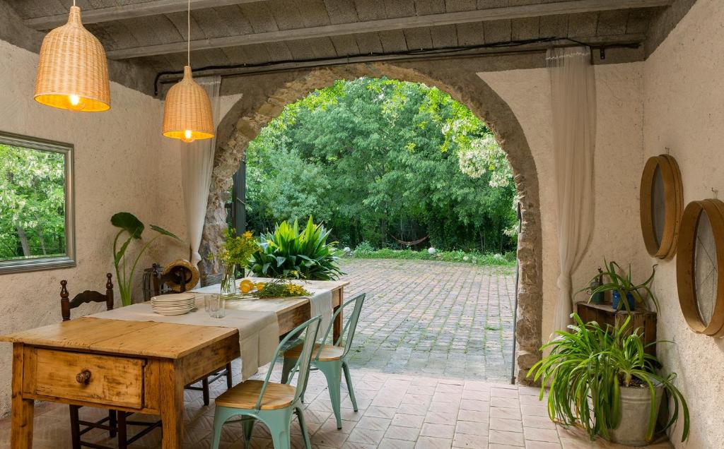 a dining room with an archway and a table and chairs at El Celler - Can Bonet in Sant Martí Vell
