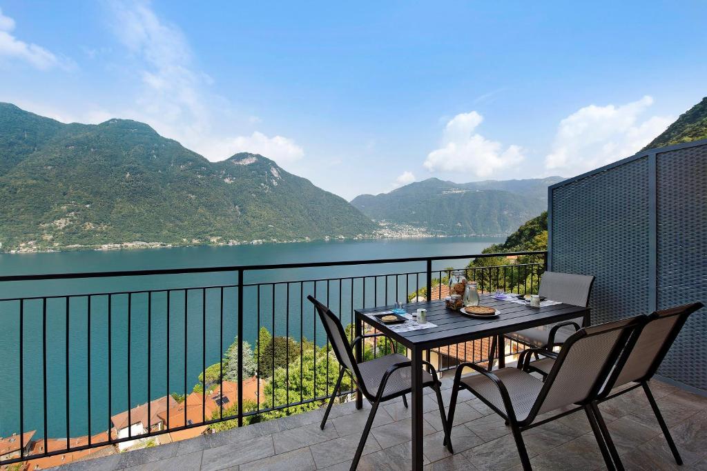 a table and chairs on a balcony with a view of the water at Appartamento 8 Il Tornante in Nesso