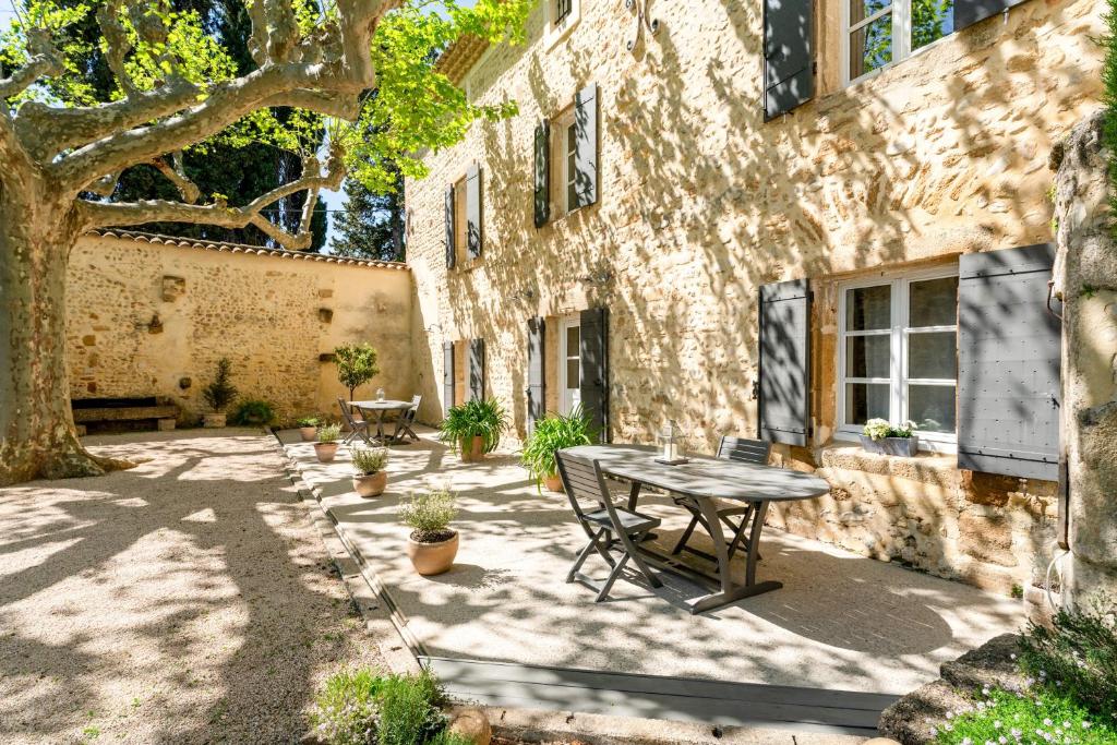 a patio with a table in front of a building at La Grange Bessac in Violès