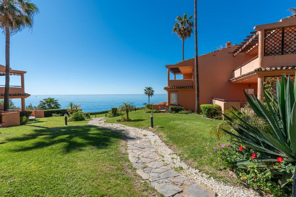 a view of a house with the ocean in the background at Front Line Beach Townhouse Estepona in Estepona
