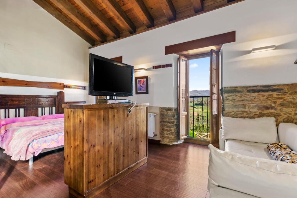 a bedroom with a bed and a flat screen tv at C de Alborada del eo in Villameitide