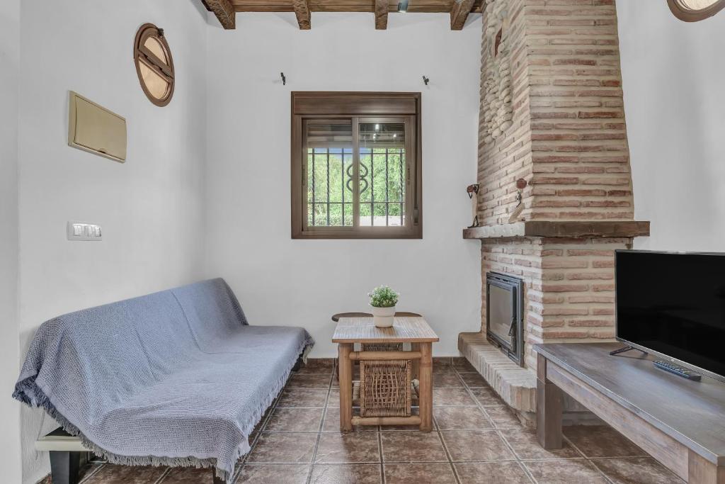 a living room with a bed and a fireplace at Casas al Alba 2 in Zahora