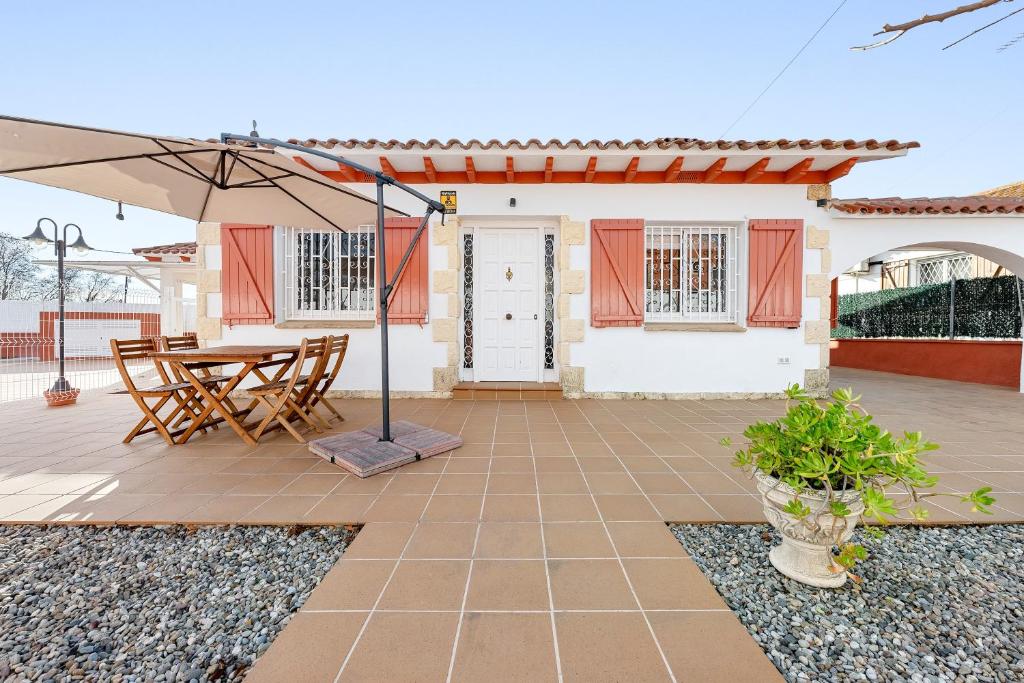 a patio with a table and an umbrella at Ca La Lola in Llorenç del Penedes