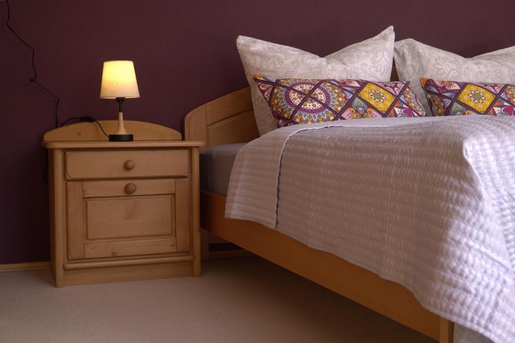 a bed with a night stand with a lamp on it at Central Home in Krumbach in Krumbach