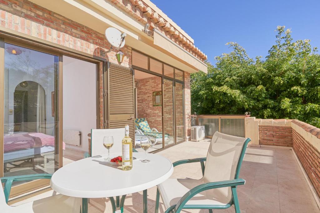 a patio with a white table and chairs on a balcony at Apartamento Ombú in La Herradura