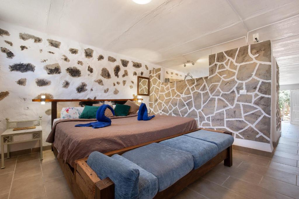 a bedroom with a bed and a stone wall at Esencia Eco-rústico Adults Only in El Charco
