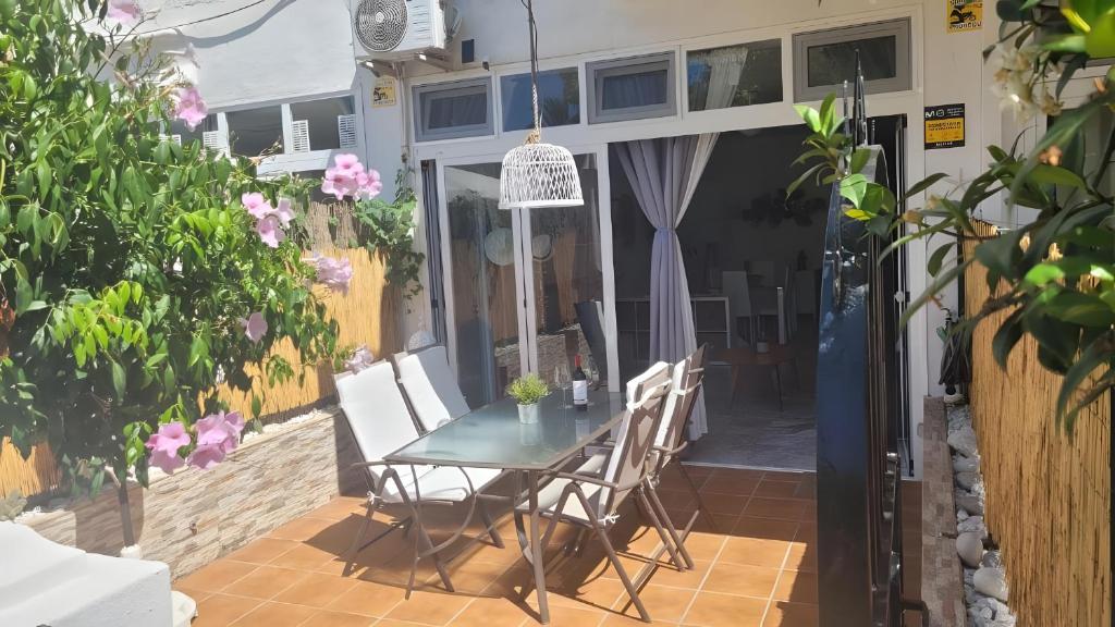 a table and chairs on a patio with flowers at Ola De Mar - Estepona in Estepona
