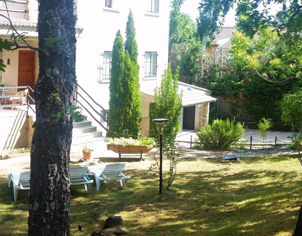 a courtyard with chairs and a building at Casa rural El rincón de Gredos in Navaluenga