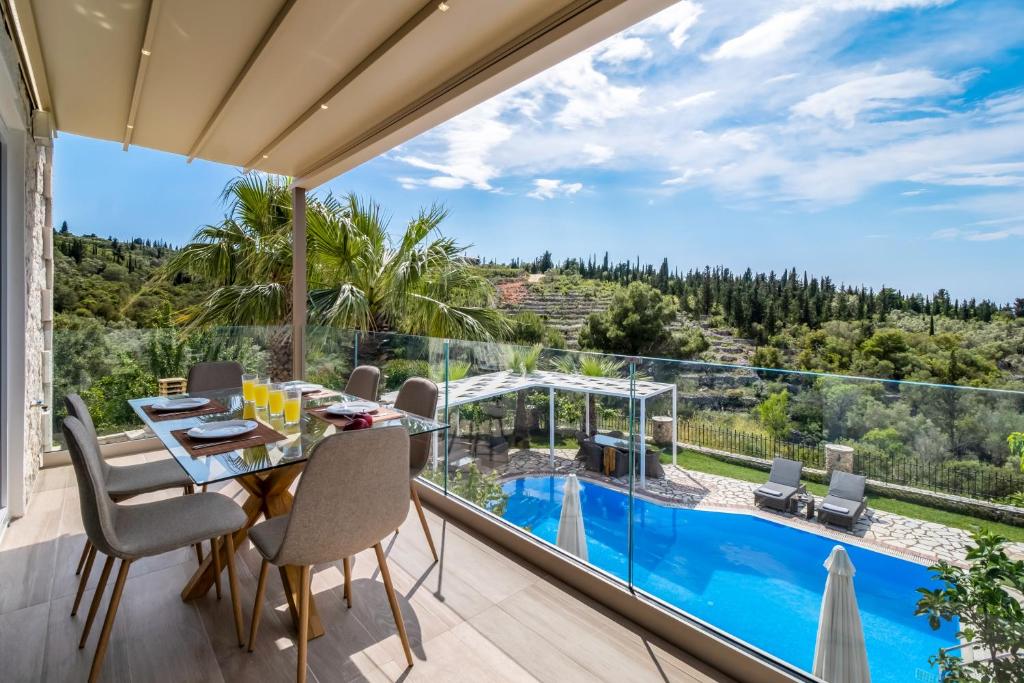 a dining room with a view of a pool at Goudis Villa Thanasis in Lefkada