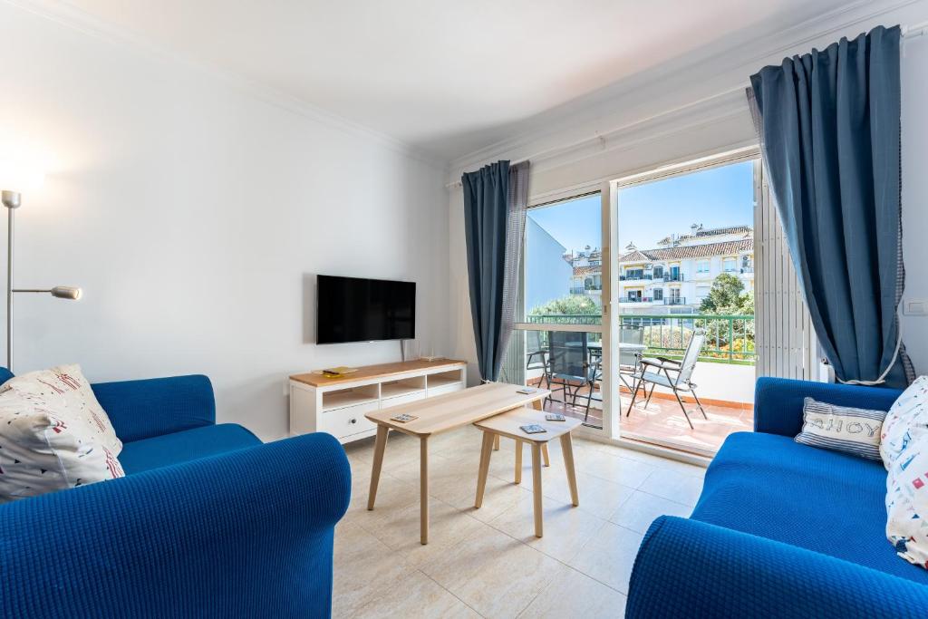 a living room with a blue couch and a tv at 234 Parque playa La cala in La Cala de Mijas