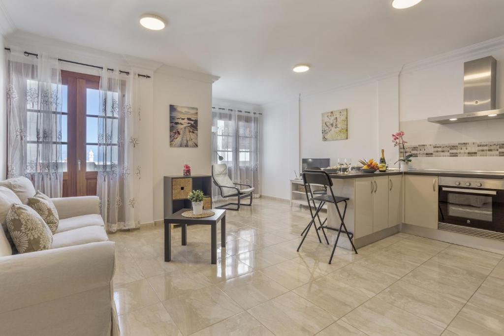 a living room with a couch and a kitchen at Apartamento Rolycar 202 in Icod de los Vinos