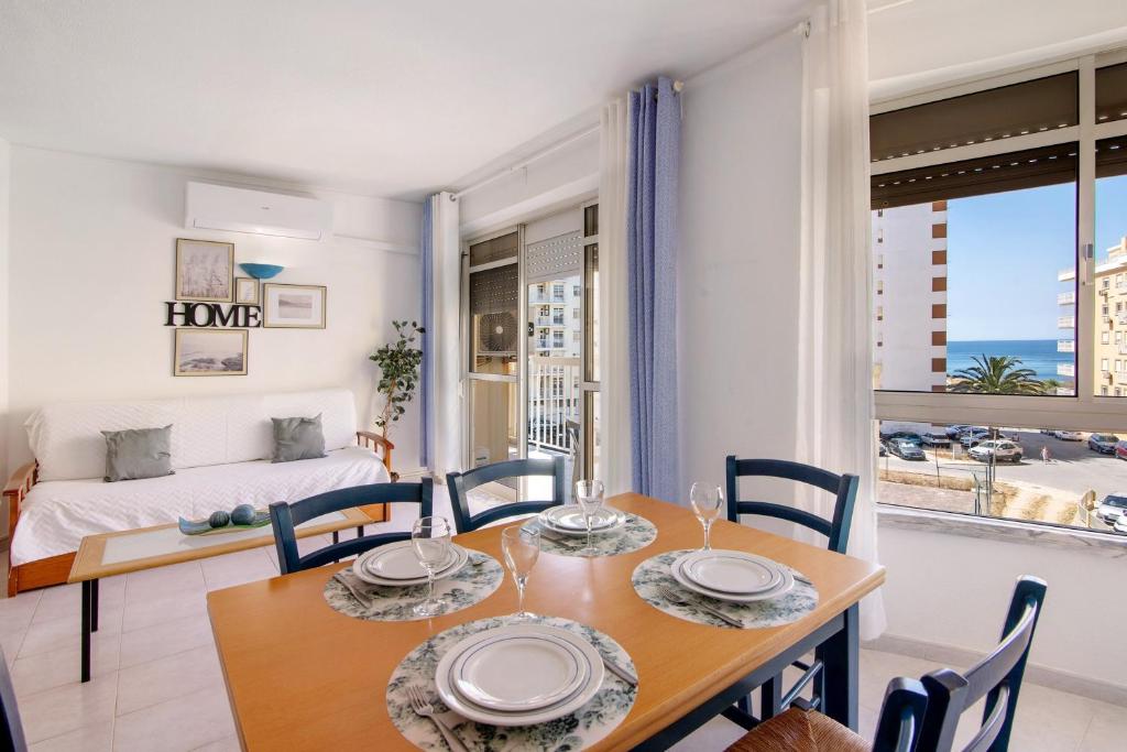 a dining room with a table and chairs and a bed at Casa Néctar in Armação de Pêra