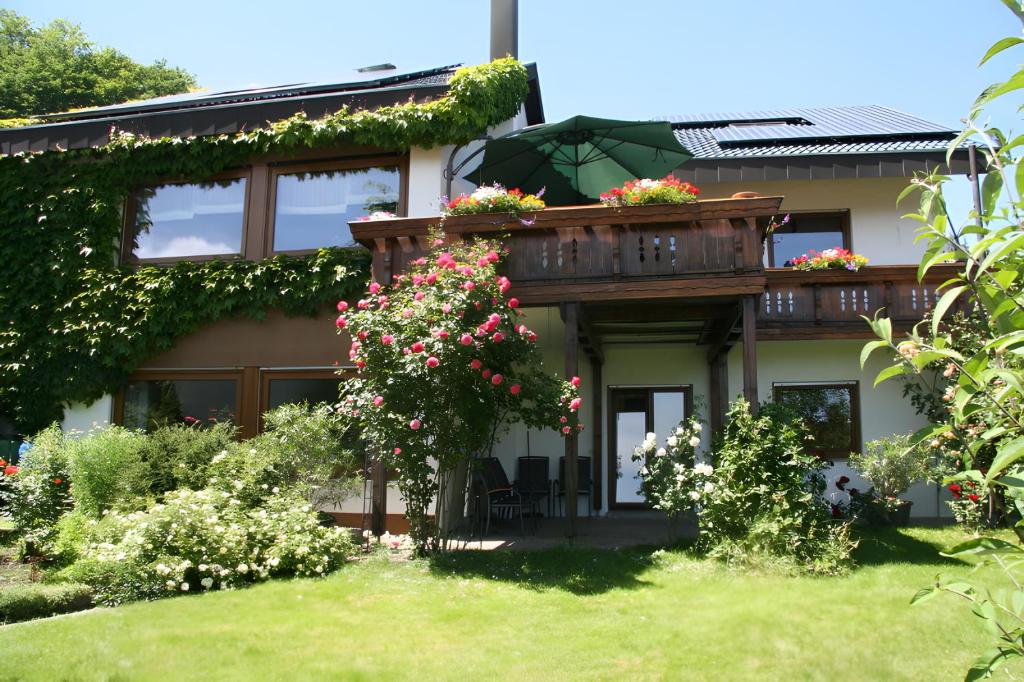 a house with a balcony with flowers on it at Ferienwohnung Kreuzbühl in Albstadt