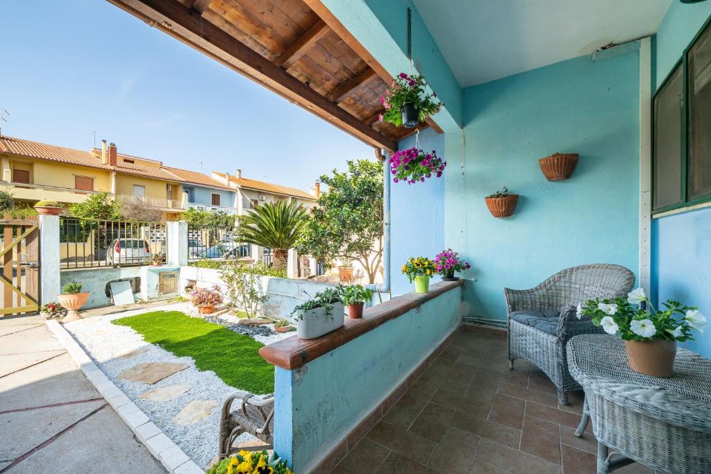 a patio with tables and chairs and a garden at Casa vacanze Elifra in San Giovanni Suergiu