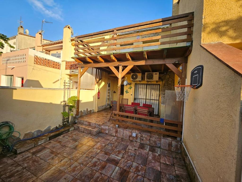 a patio with a pergola on the side of a building at Casa entera Empuriabrava y terraza in Empuriabrava
