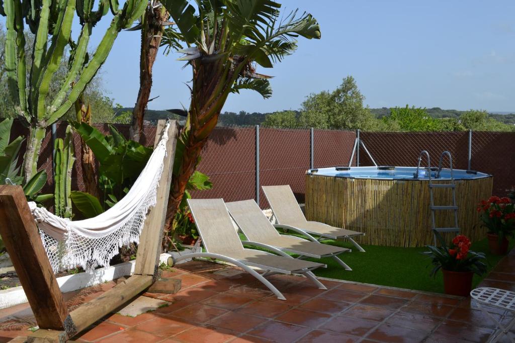 a patio with a hammock and a hot tub at Casa Ohanna in Vejer de la Frontera