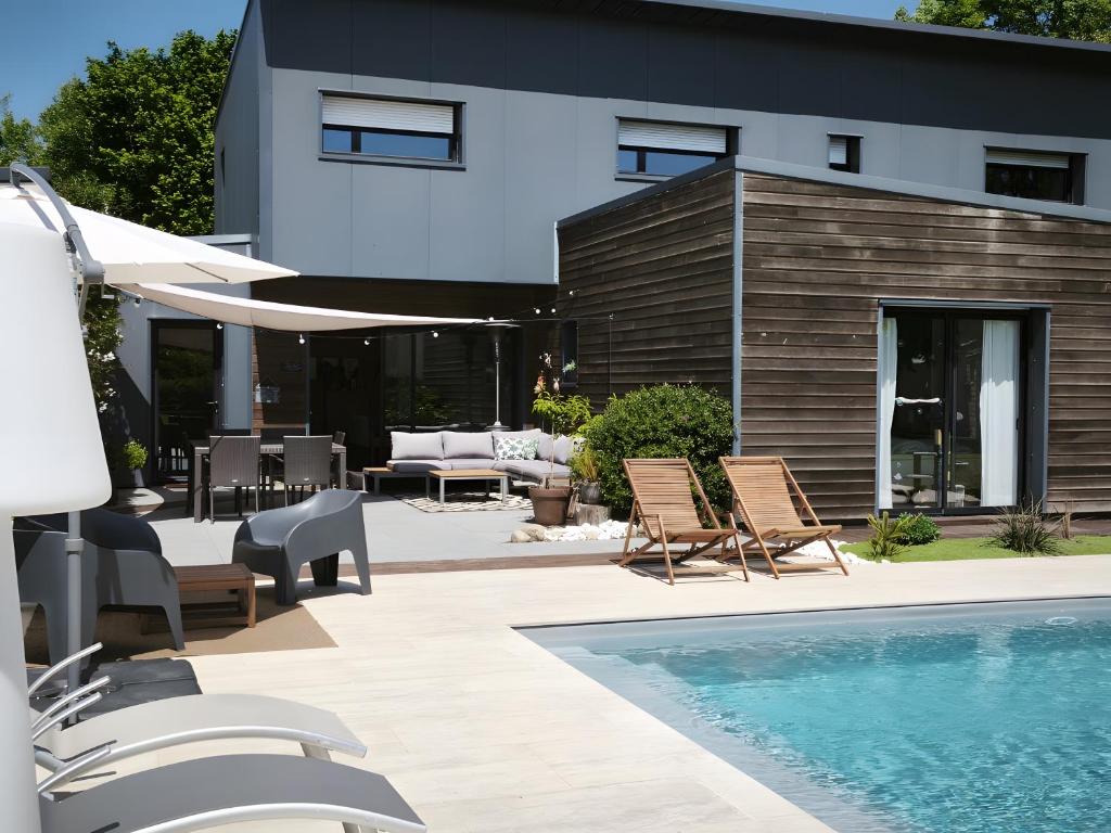 a patio with chairs and a swimming pool at La Fée Maison, chambres d'hôtes in Plouër-sur-Rance