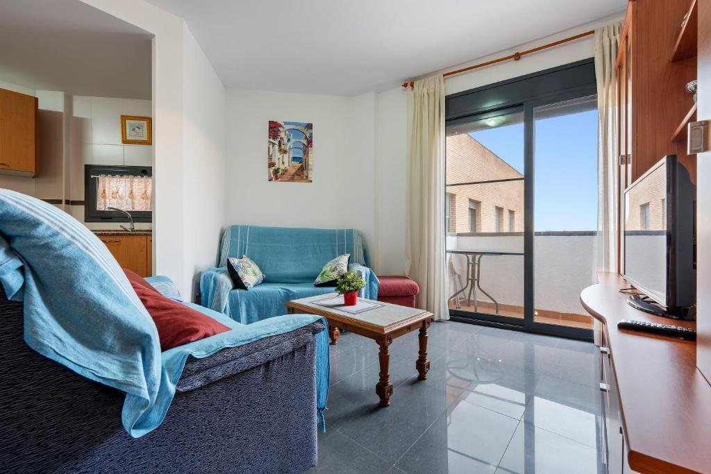 a living room with a blue chair and a tv at Deltebre riu in Deltebre