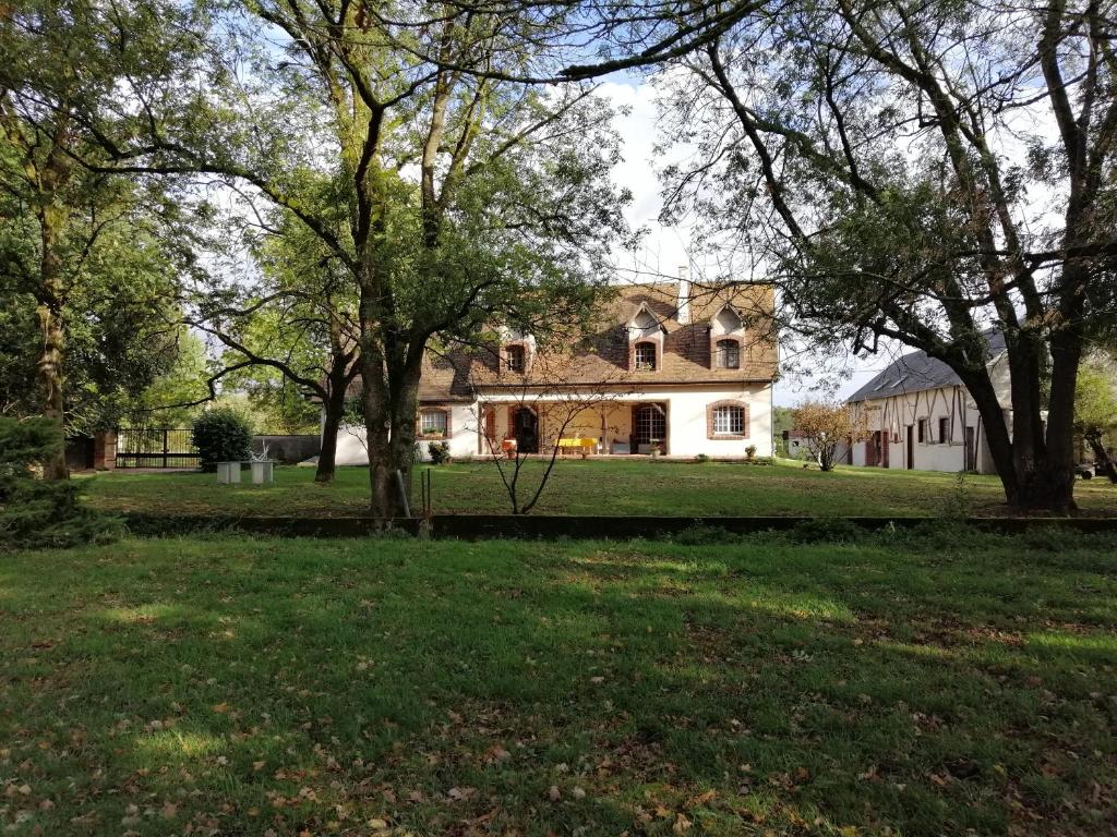ein großes weißes Haus mit Bäumen im Garten in der Unterkunft Les Alliots in Coullons
