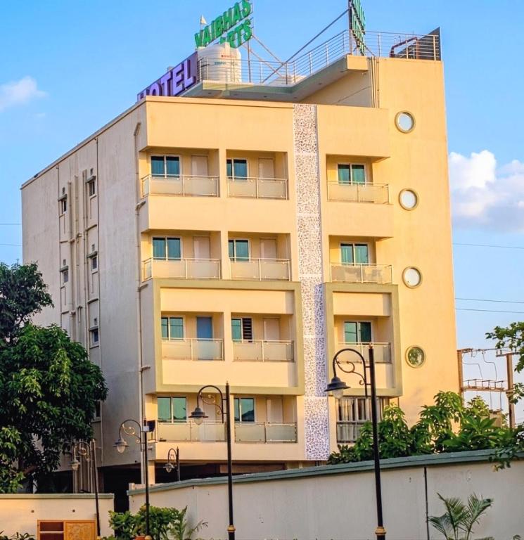 a yellow building with a sign on top of it at Baibhab Convention & Resort in Bhubaneshwar