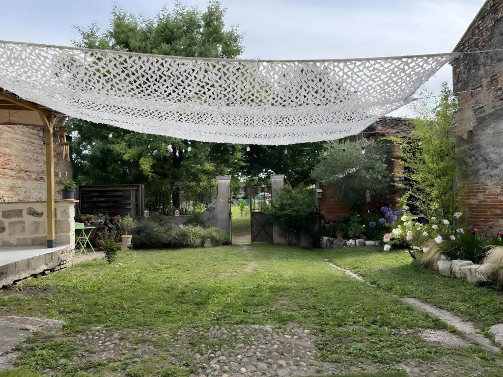 a garden with a net over a yard at Chambre d'hôte Léontine in Lamagistère