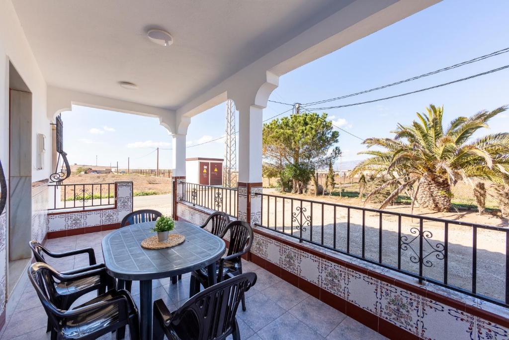 a balcony with a table and chairs and a view of the desert at Nazareno in Níjar