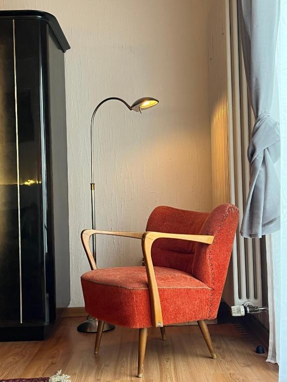 a red chair sitting next to a lamp in a room at Auf dem Karlsberg in Weilburg