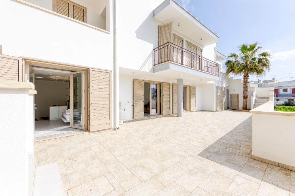 an empty courtyard of a house with a balcony at Appartamenti a 50 m dal mare in Torre San Giovanni Ugento