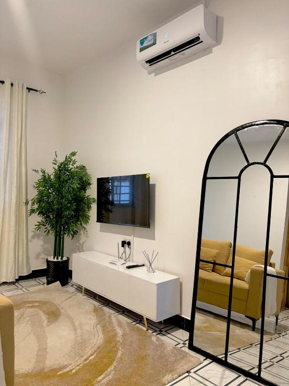 a living room with a white table and a mirror at Two bedrooms apartment in Moshi town in Moshi