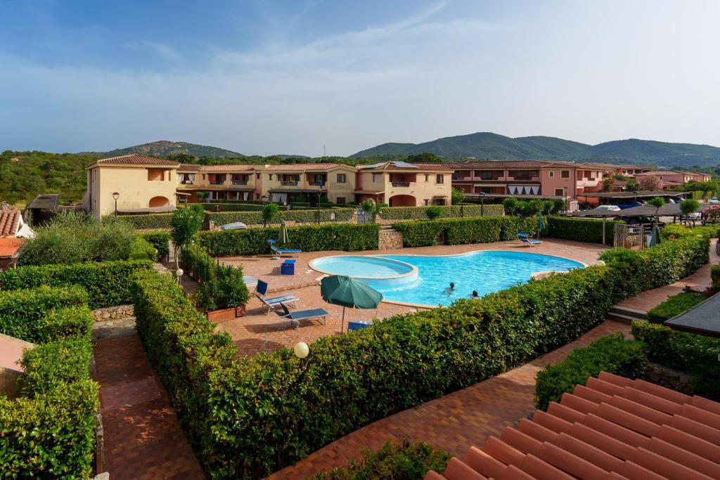 a resort with a swimming pool and some bushes at Casa Vacanze Fragola in Olbia