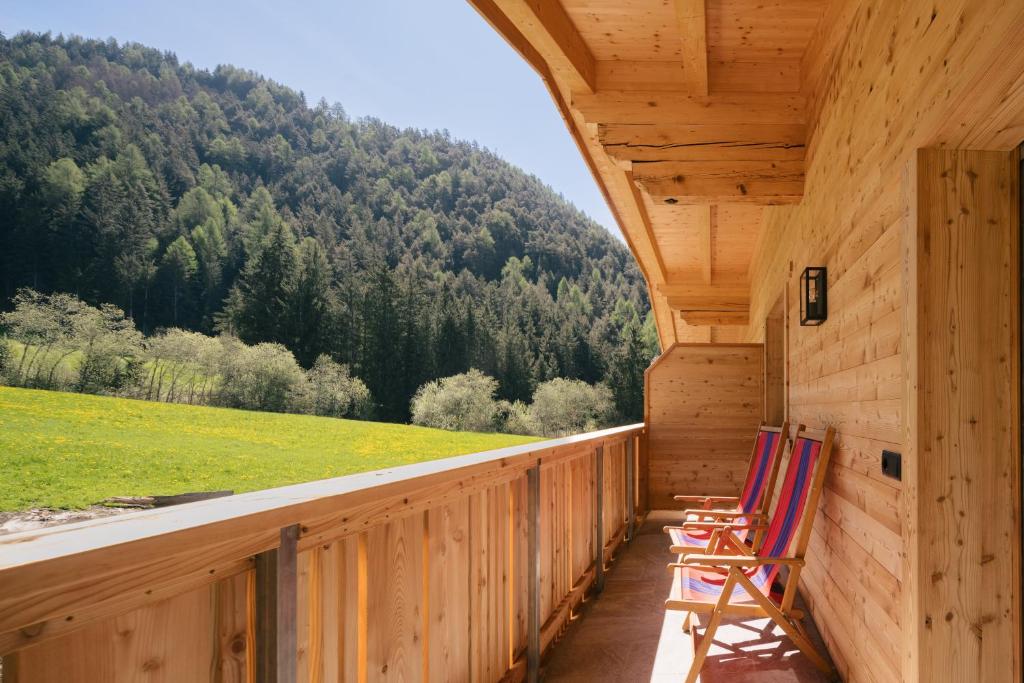 two chairs sitting on the porch of a cabin at Balbeinhof Apt Reh in Luson