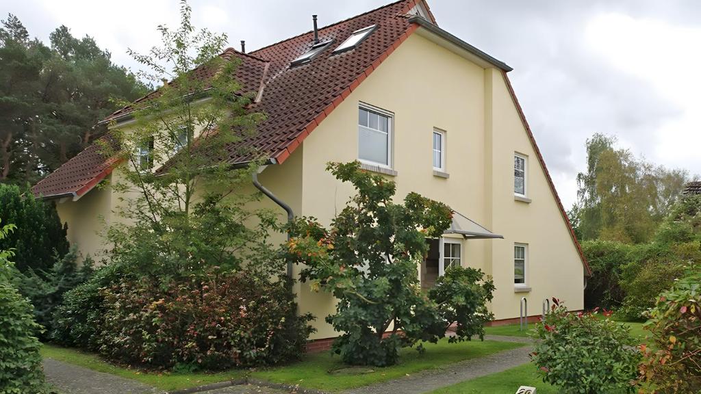 a yellow house with a red roof at Sommergarten mit Winternutzung in Karlshagen