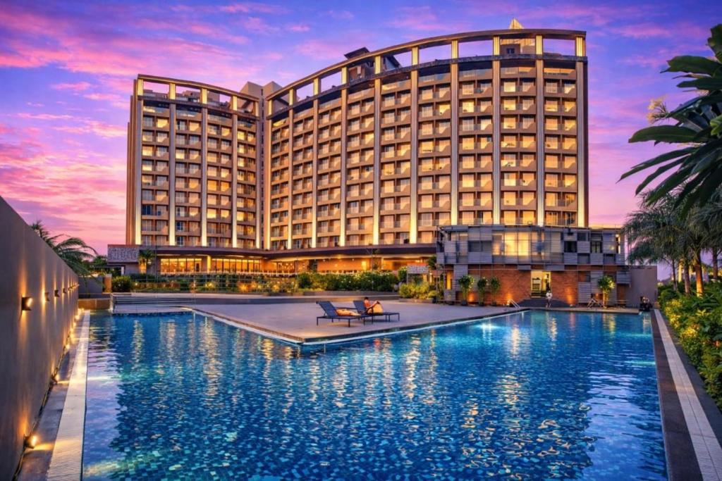 a hotel with a pool in front of a building at The Weekend Address Managed By Stayzy in Dumas
