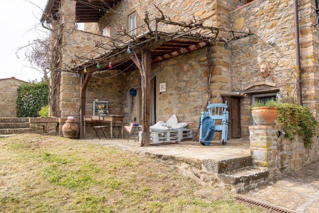 a stone house with a patio with a table and chairs at Camera con Vista in Anghiari