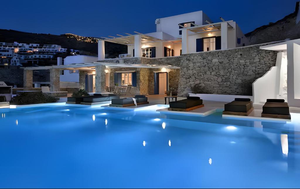a villa with a swimming pool at night at Villa Crysta Mykonos in Mikonos