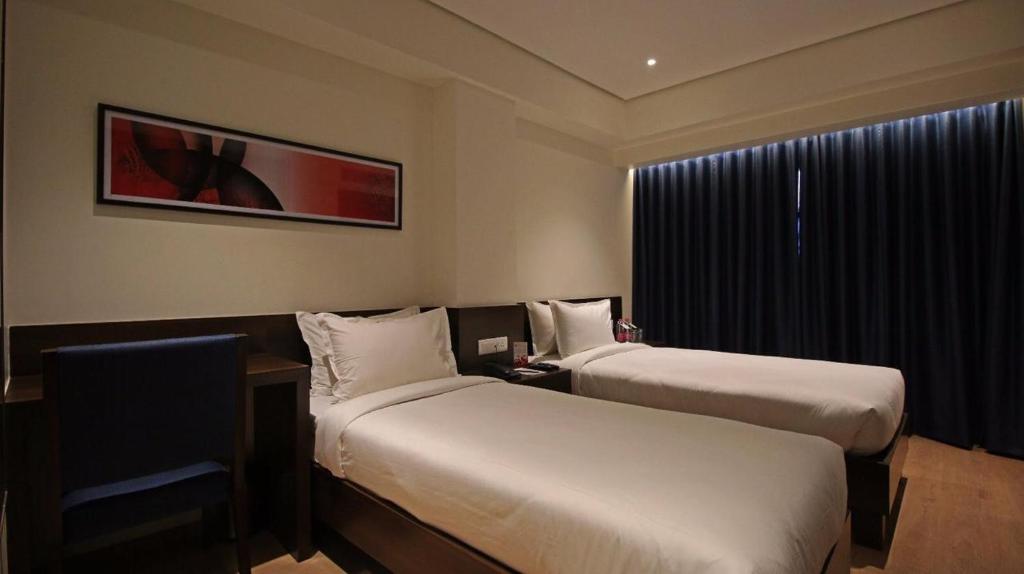 a hotel room with two beds and a window at Hotel German Palace Near to Airport in Gandhinagar
