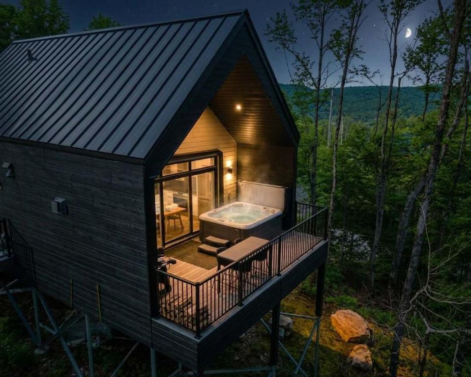 a tiny house with a hot tub on the deck at Elska - SPA and Mountain in Saint Come