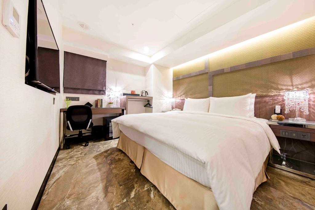a hotel room with a large bed and a desk at Hotel I Journey in Taipei