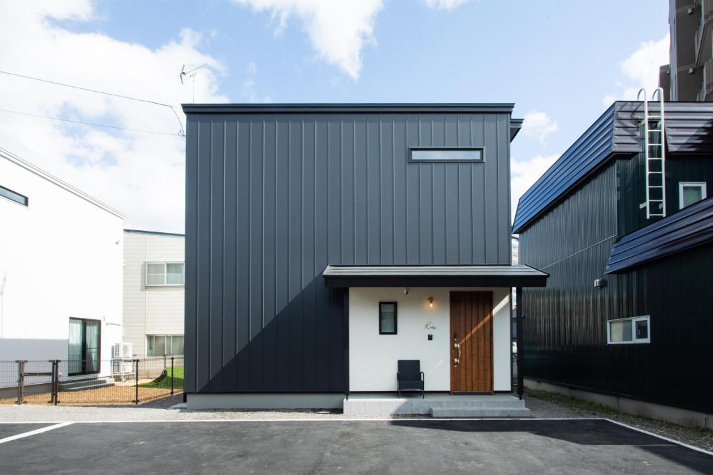 a black and white house with a white door at Kuro in Hakodate