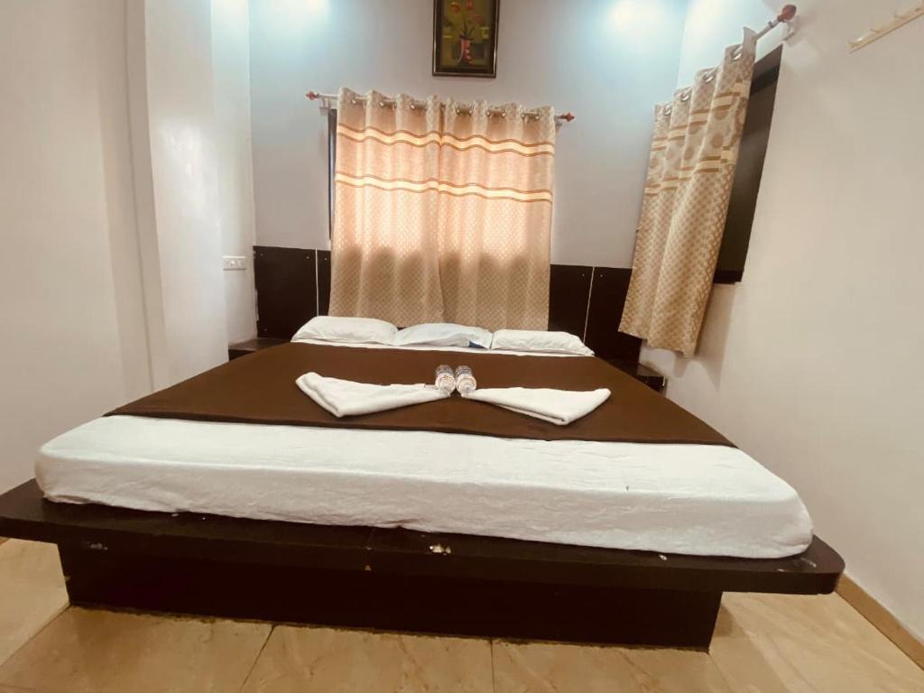 a bedroom with a bed with two white towels on it at Bbhakt niwas in Tuljapur