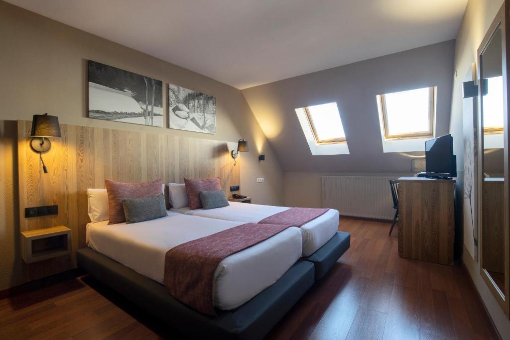 a bedroom with a large bed in a room with windows at Hotel Grand Pas by Nexta in Pas de la Casa