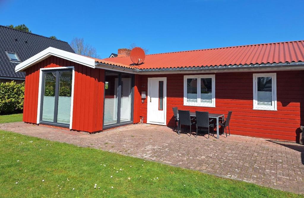 a red house with a table and chairs in front of it at Ferienpark Achtern Diek Ferienhaus Malmö in Otterndorf