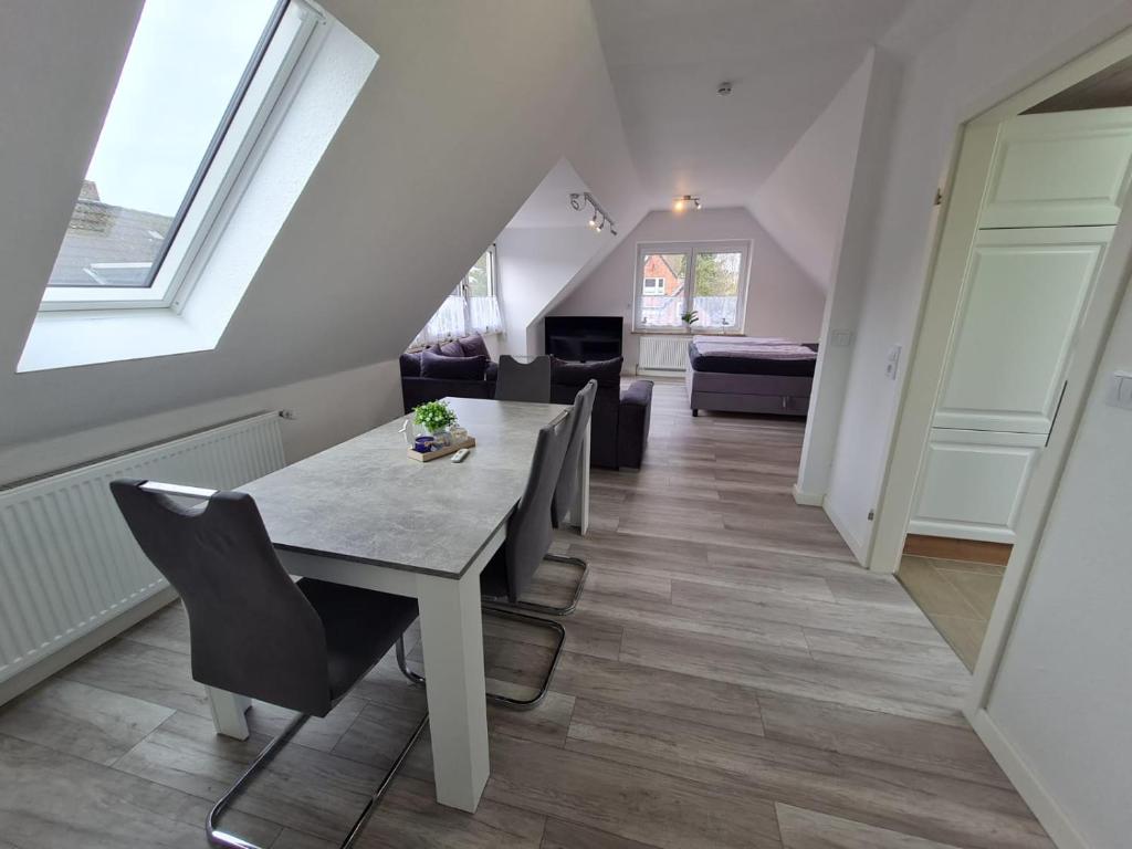 a dining room with a table and chairs and a living room at Ferienwohnung Inselblick Vitzdorf in Fehmarn