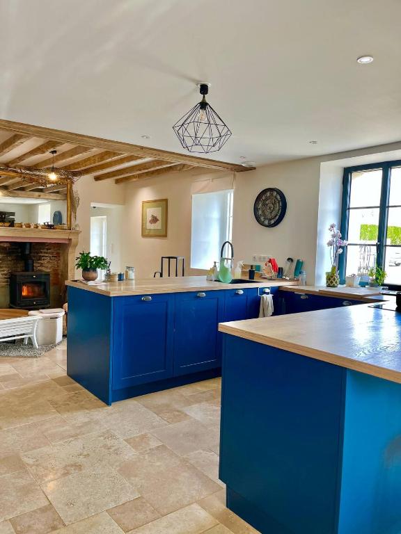 a large kitchen with blue cabinets and a counter top at Cadre d'exception et nature - 2 Maisons - 15 pers max in Aigné