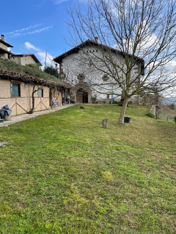 a large stone building with a tree in the yard at Iregi Natura Casa Rural in Oskotz