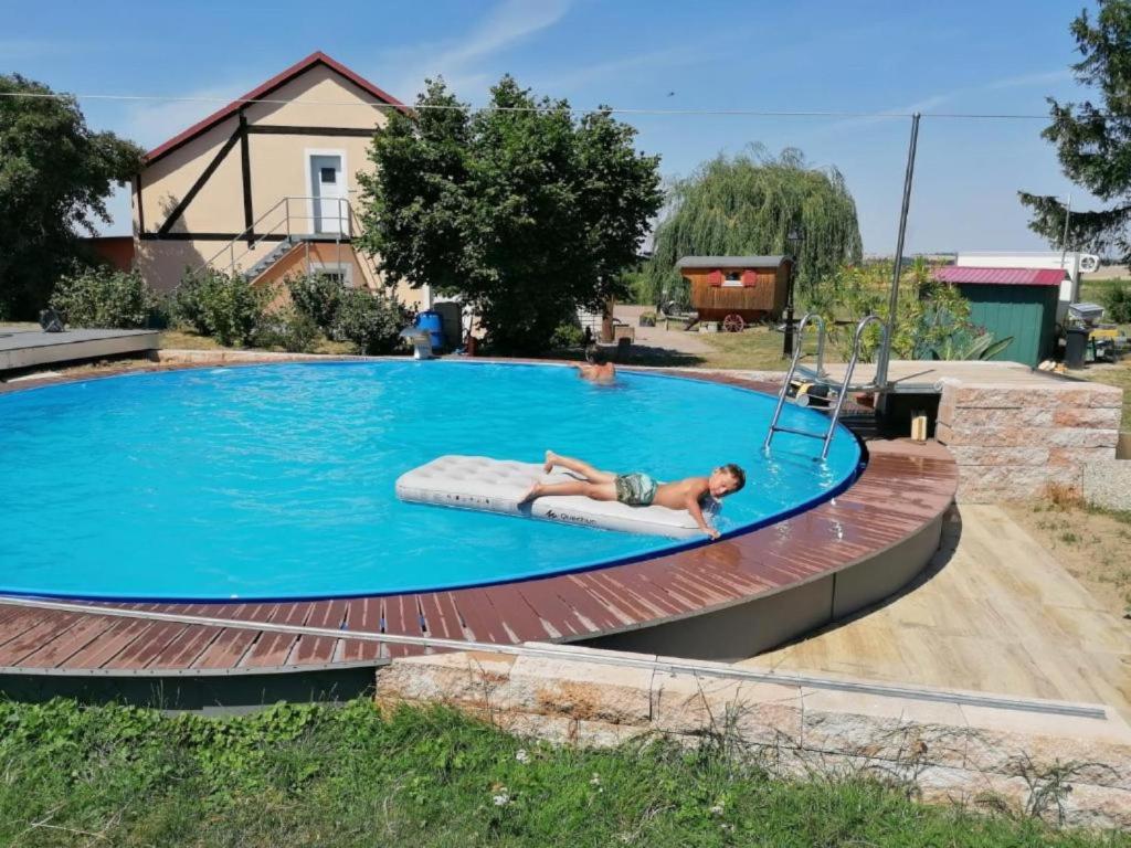 a man laying on a raft in a swimming pool at Hof Grübler in Klipphausen