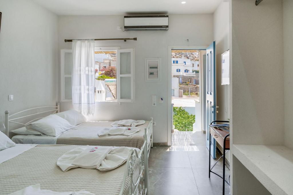 two beds in a room with a window at Politimis Studio N3 in Amorgos