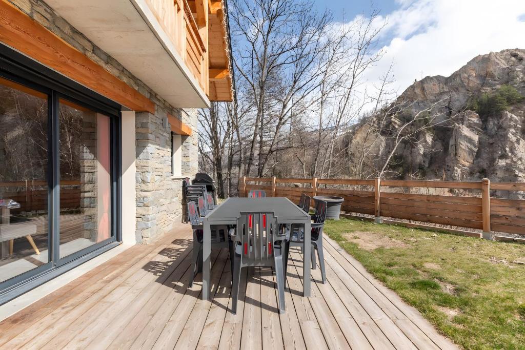 a patio with a table and chairs on a deck at Chalet Les Lys - Tout Confort in Valloire