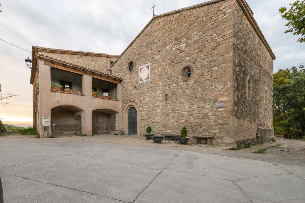 a large brick building with two benches in front of it at Casa refugi les Orenetes in Rocafort